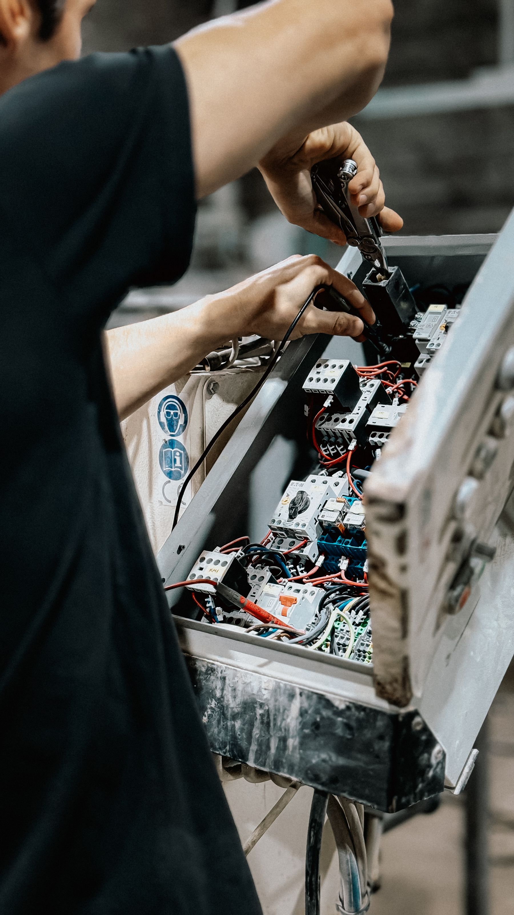 Technician maintaining an electrical control panel