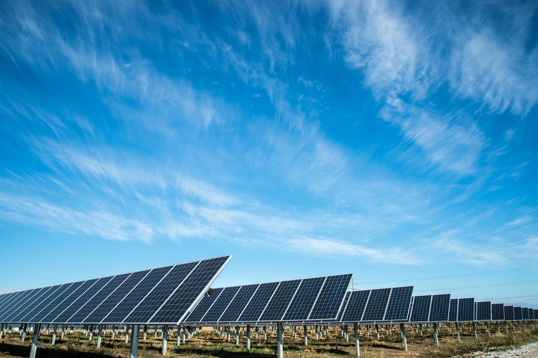 Utility-scale solar photovoltaic panels beneath a clear sky